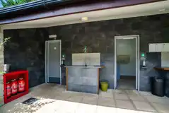 Facilities block with male and female bathrooms, plus an outdoor washing up sink