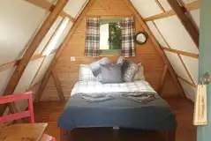 Original couple camping pod interior double bed and dining area