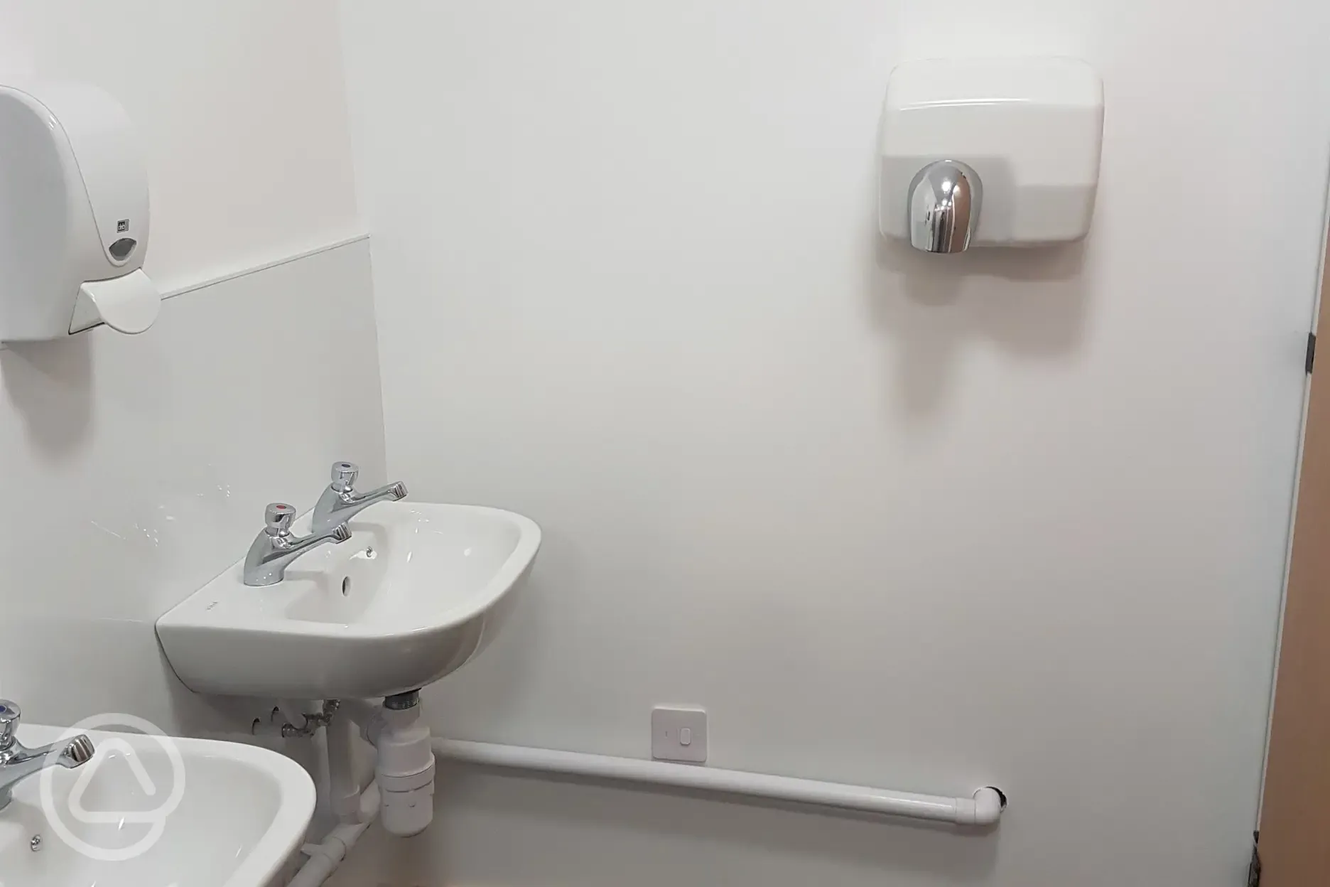 Sinks in the shared bathrooms with hand dryers