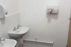 Sinks in the shared bathrooms with hand dryers
