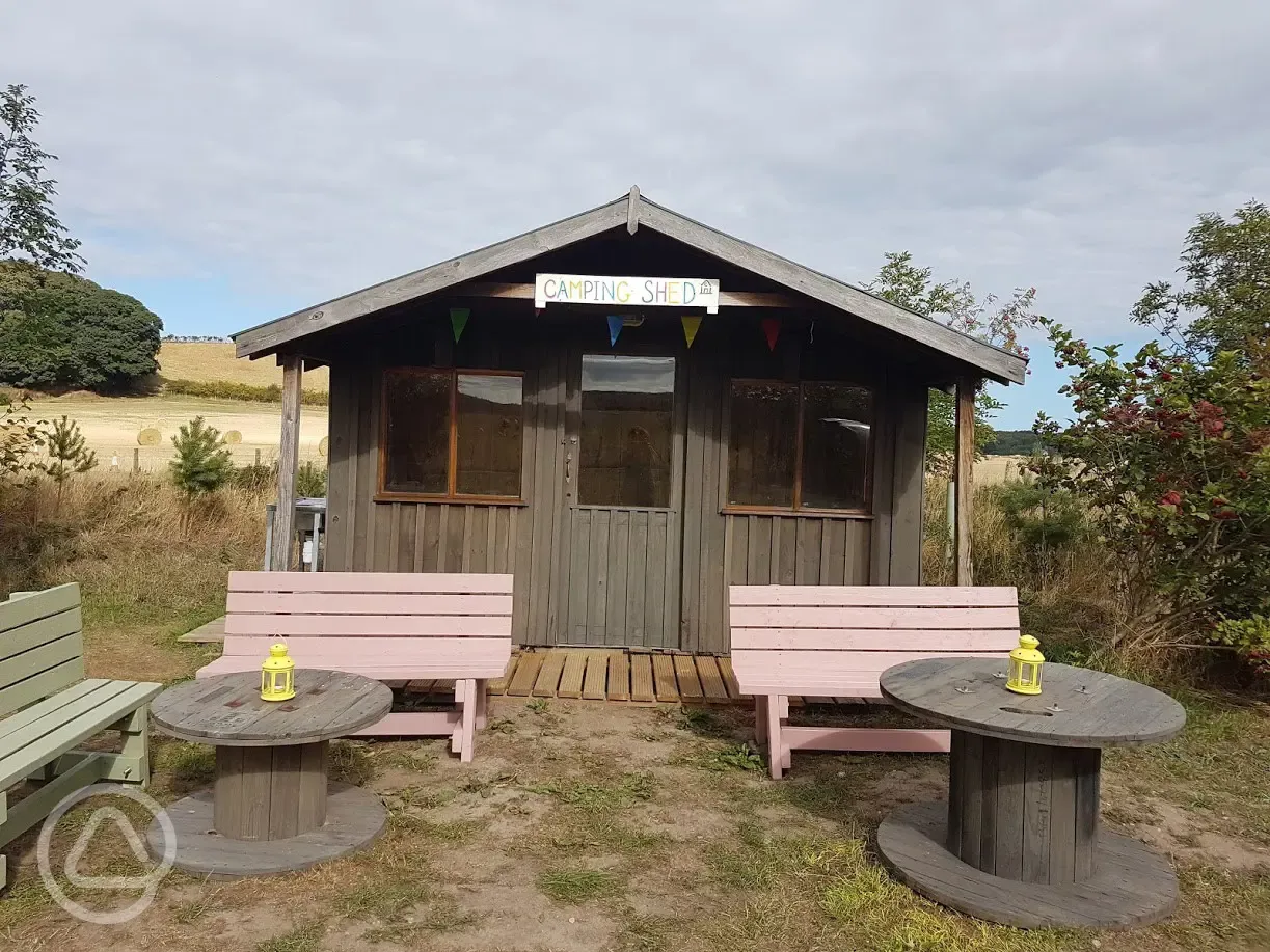 Camping shed with cooking facilities and seating area