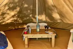 Bell tents furnished with beds, a table and cooking equipment