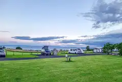 Fully serviced hardstanding pitches (6m x 10m) at dusk with sea views Fully serviced hardstanding pitches (6m x 10m) at dusk with sea views