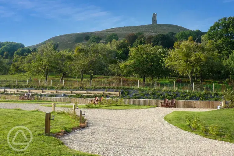 Electric hardstanding touring pitches with views of the Glastonbury Tor