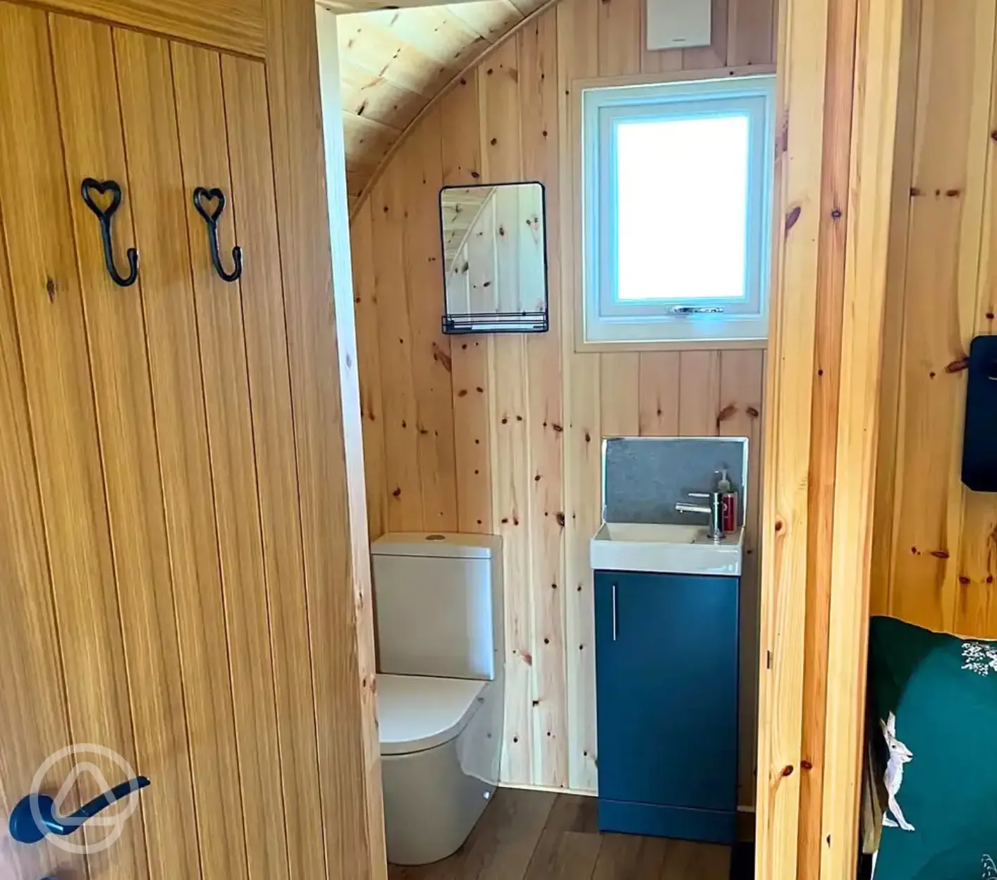 Pod ensuite bathroom with toilet, sink, shower and towels
