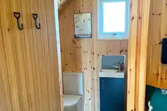 Pod ensuite bathroom with toilet, sink, shower and towels