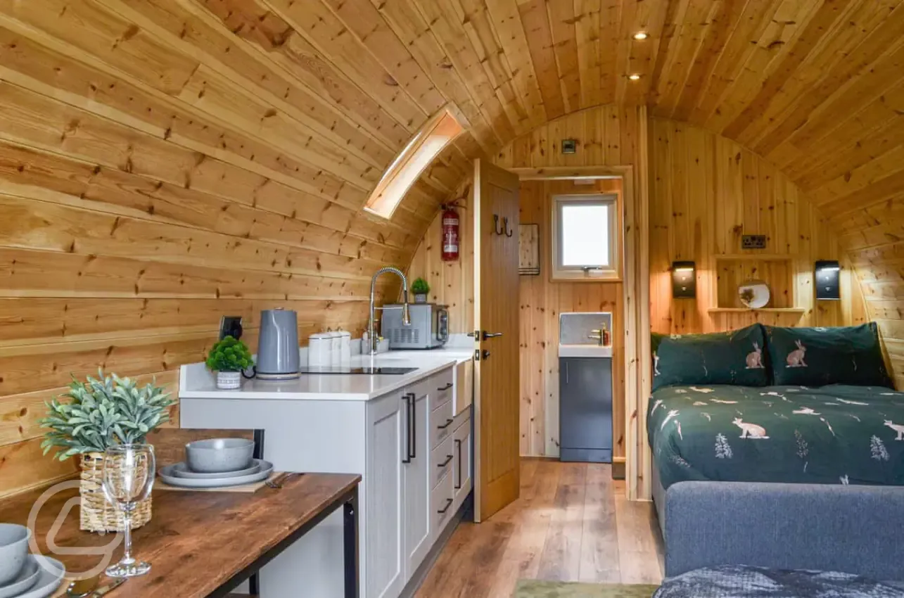 Ensuite glamping pod interior with a double bed and double sofa bed