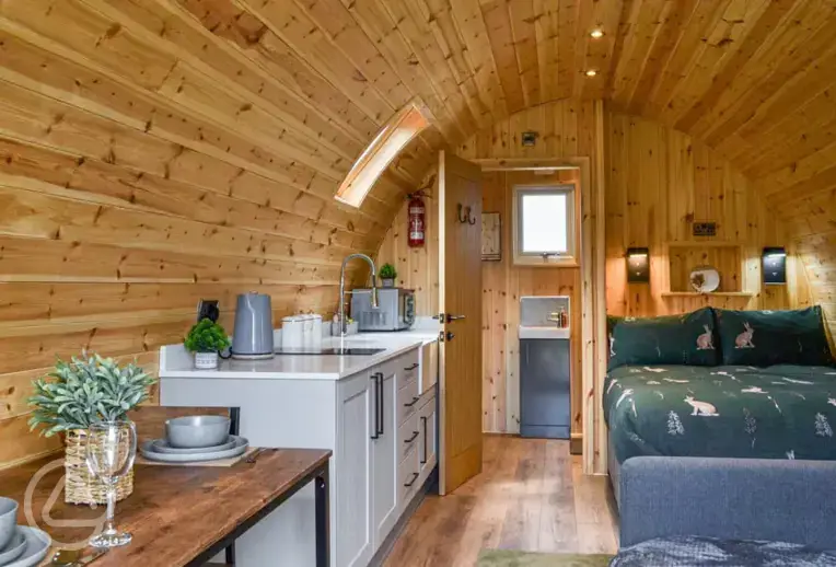 Ensuite glamping pod interior with a double bed and double sofa bed
