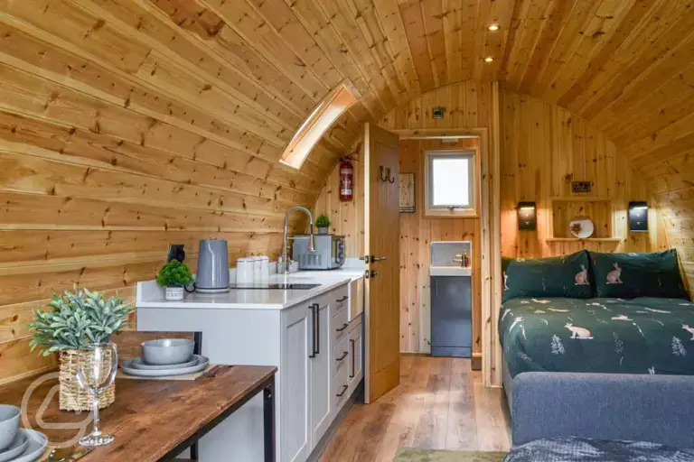 Ensuite glamping pod interior with a double bed and double sofa bed