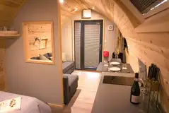 Castle pod with a double bed, large sofa, kitchen and ensuite bathroom
