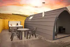 Castle glamping pods with a large outdoor deck and hot tub