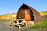 Glamping pods with a picnic bench and hot tub