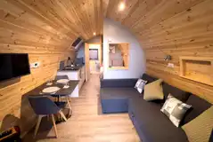 Castle pod with a double bed, large sofa, kitchen and ensuite bathroom