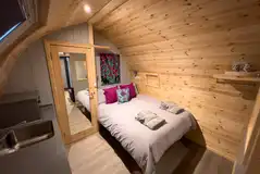 Castle pod with a double bed, large sofa, kitchen and ensuite bathroom