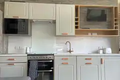 Hill top lodge kitchen with an oven, microwave, sink, fridge and TV