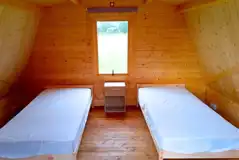 Glamping pod interior with two single beds, bed linen is not provided Glamping pod interior with two single beds, bed linen is not provided