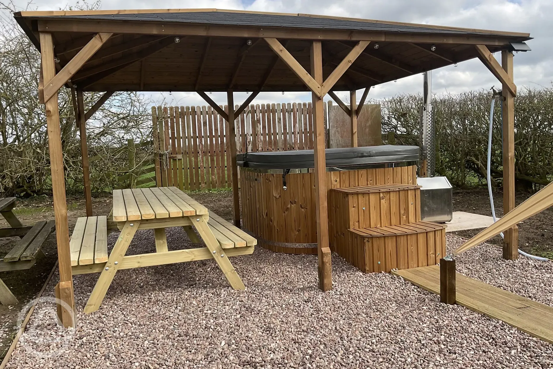 Plus Deluxe Lotus Belle Tent with square hot tub under gazebo with seating