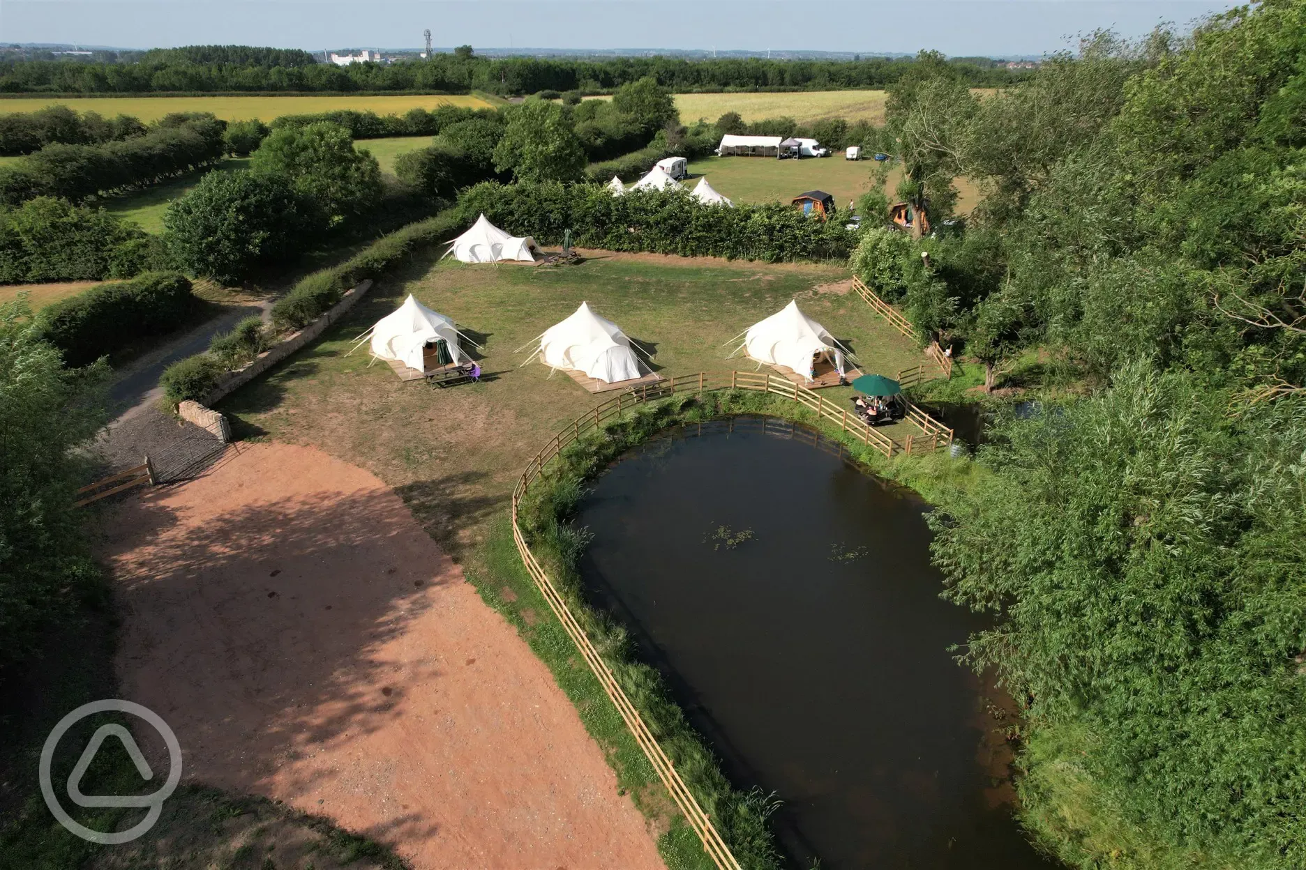Aerial view of Lotus Belle Tents by the pond and surrounded by countryside