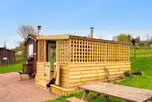 The Old Ram's shepherd's hut with a covered outdoor area and hot tub