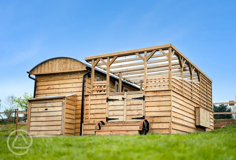 Just For Ewe shepherd's hut with a covered outdoor area and hot tub