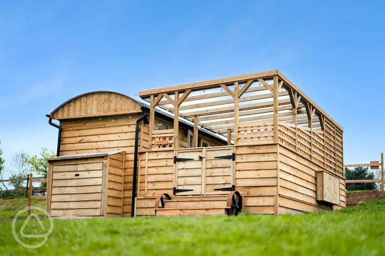 Just For Ewe shepherd's hut with a covered outdoor area and hot tub