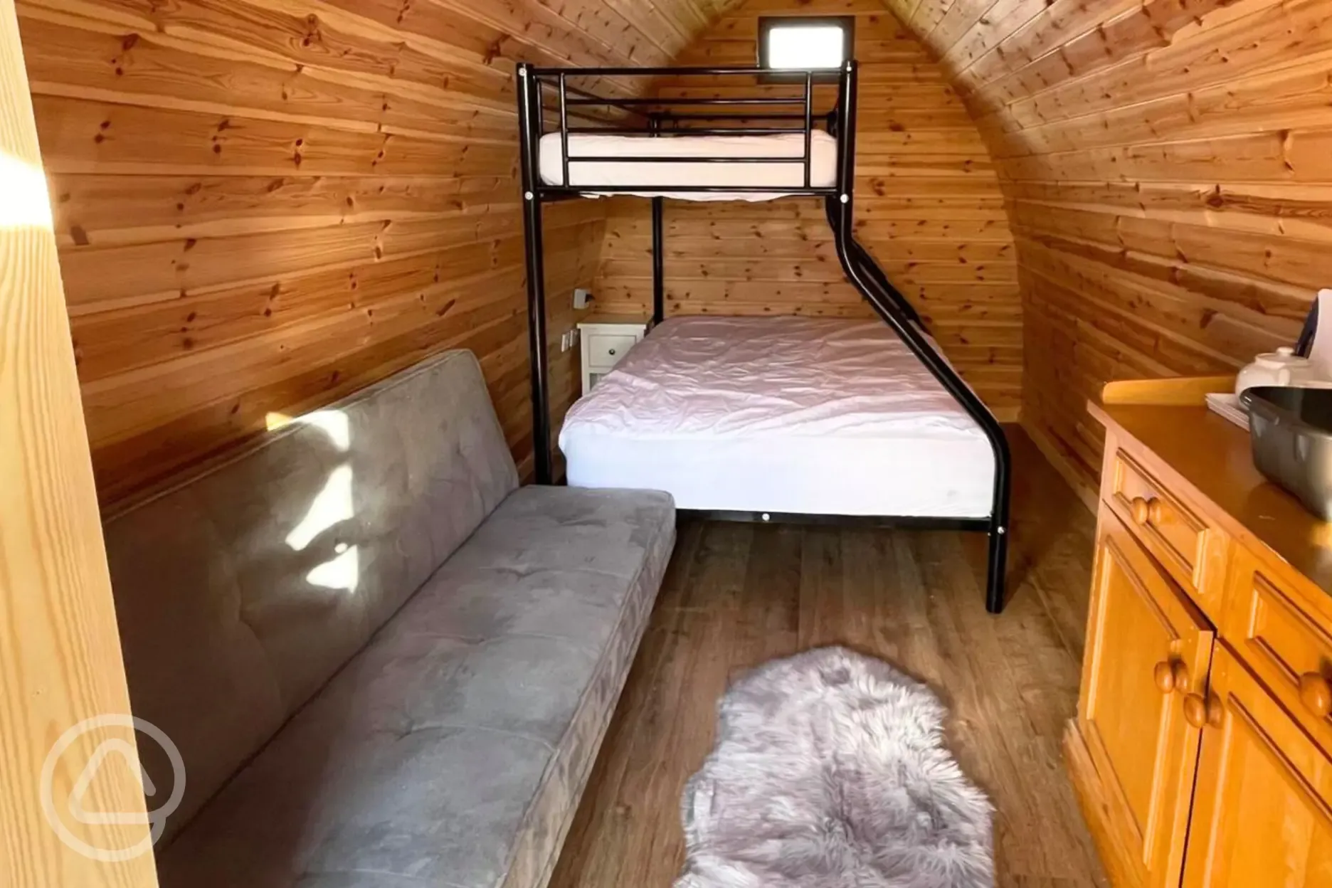 Camping pod interior with a double bed, single bunk and sofa bed