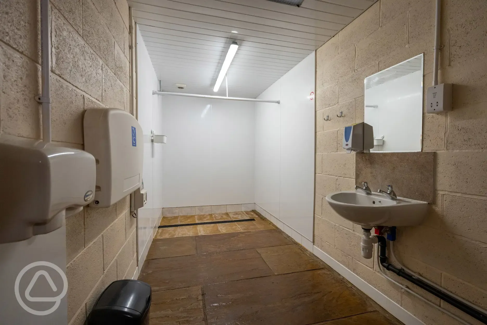 Disabled washroom with accessible shower, sink, mirror and baby changing station