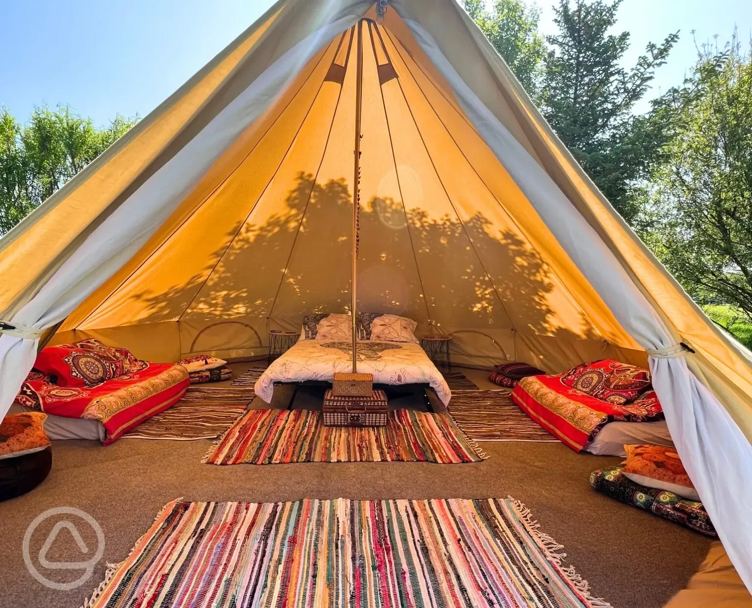 Bell tent interior with double bed and two single beds