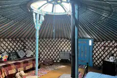 Yurt interior with double bed and two single beds Yurt interior with double bed and two single beds