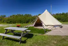 Bell tent exterior with picnic bench and solar lighting available Bell tent exterior with picnic bench and solar lighting available