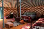 Emperor bell tent interior with a double bed, two singles, and bedding
