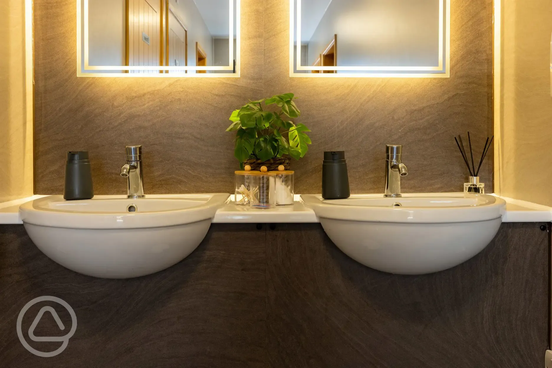 Modern facilities block with light up mirrors and toiletries