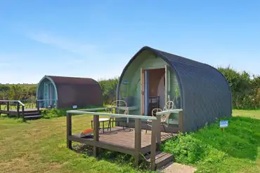 Camping pods with outdoor deck areas and furniture