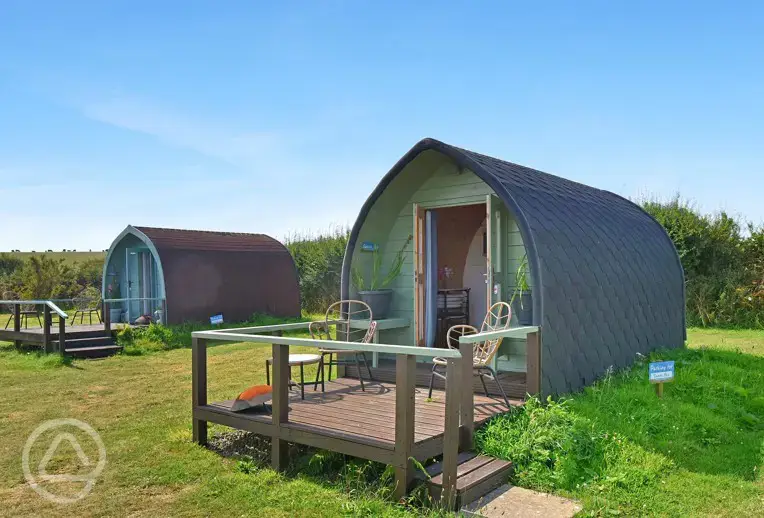 Camping pods with outdoor deck areas and furniture