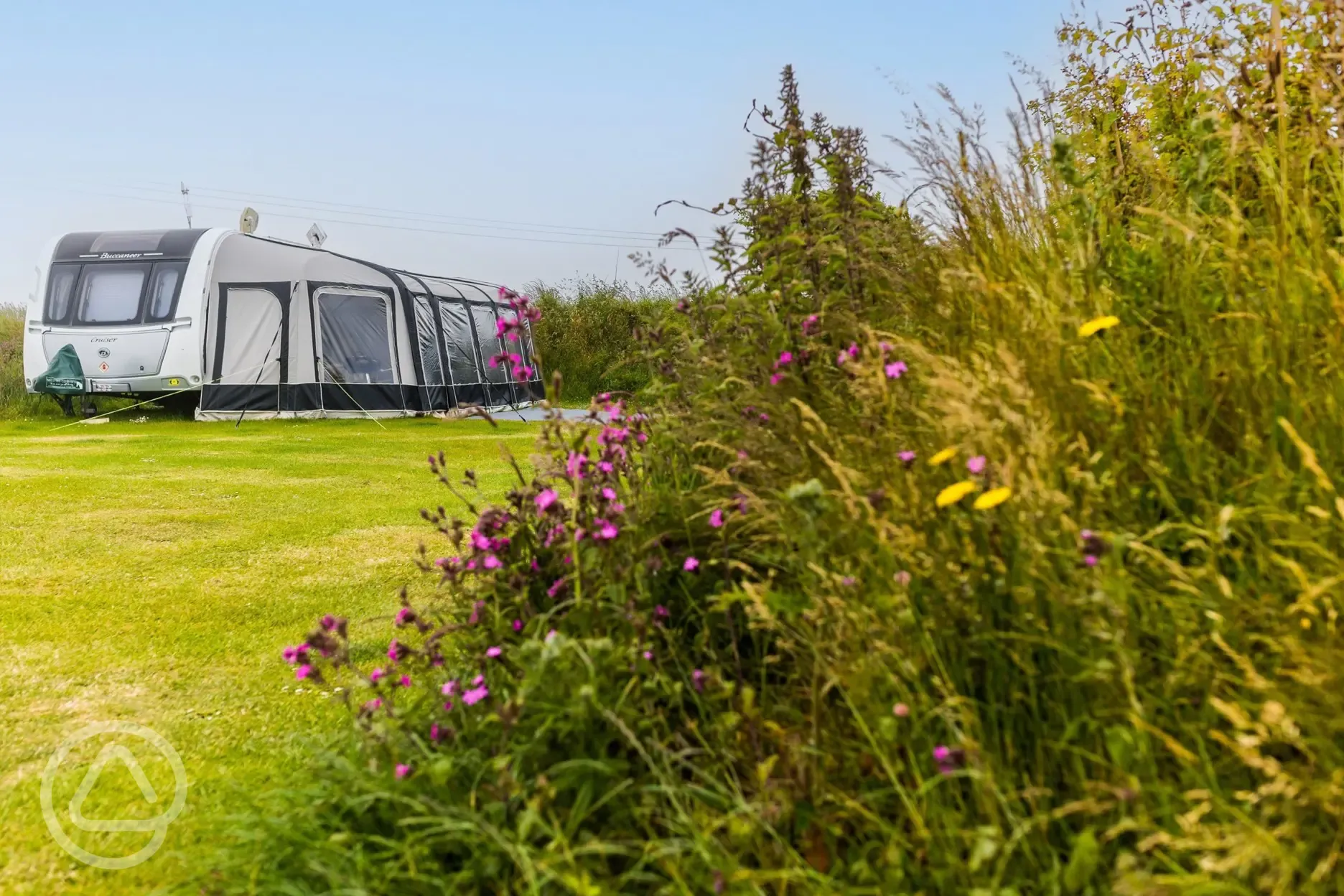 Caravan on non electric grass pitch secluded by bushes with awning space