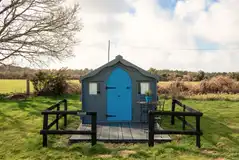 Eco pod exterior and decking, surrounded by countryside
