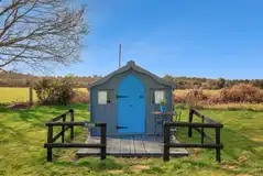 Eco pod exterior and decking, surrounded by countryside