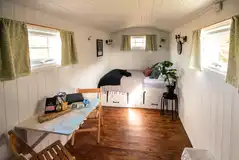 Shepherd's Hut interior with double bed and dining area