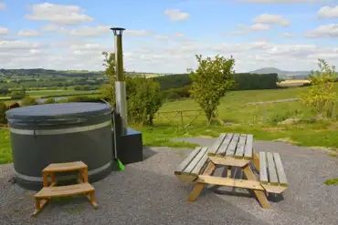 Caradoc Lodge private wood-fired hot tub and picnic bench