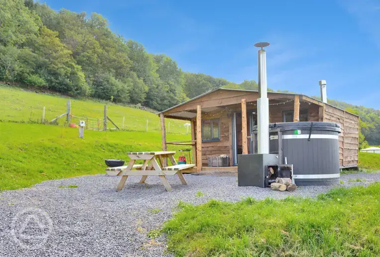 Caradoc Lodge with a wood-fired hot tub and picnic bench