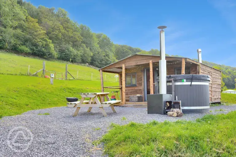 Caradoc Lodge with a wood-fired hot tub and picnic bench