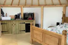 Roundhouse interior with a double bed and kitchenette Roundhouse interior with a double bed and kitchenette