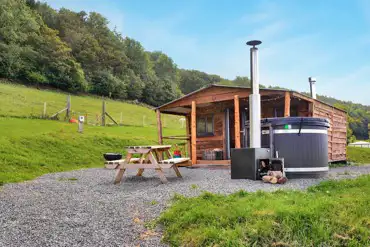 Caradoc Lodge with a wood-fired hot tub and picnic bench
