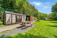 Rail cabins at Moss Side Farm Campsite with an outdoor picnic bench