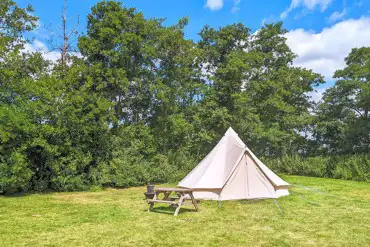 Bell tents with a picnic table and fire pit