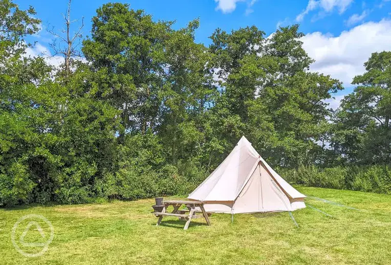 Bell tents with a picnic table and fire pit