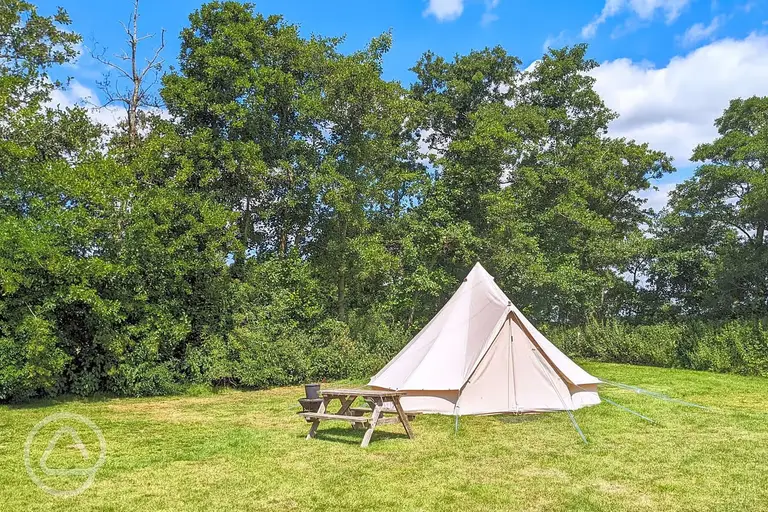 Bell tents with a picnic table and fire pit