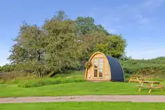 Camping pod exterior with outdoor seating, sleeping up to three