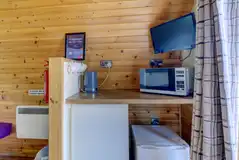 Large hiker pod interior with fridge, mugs, kettle and microwave