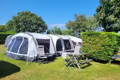 Large tent on an electric grass pitch with a 16 amp hook up with privacy hedges Large tent on an electric grass pitch with a 16 amp hook up with privacy hedges